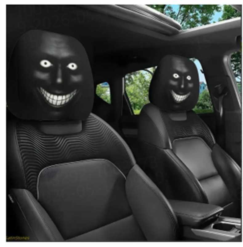 Two black car headrest covers with glowing eyes and a wide toothy grin