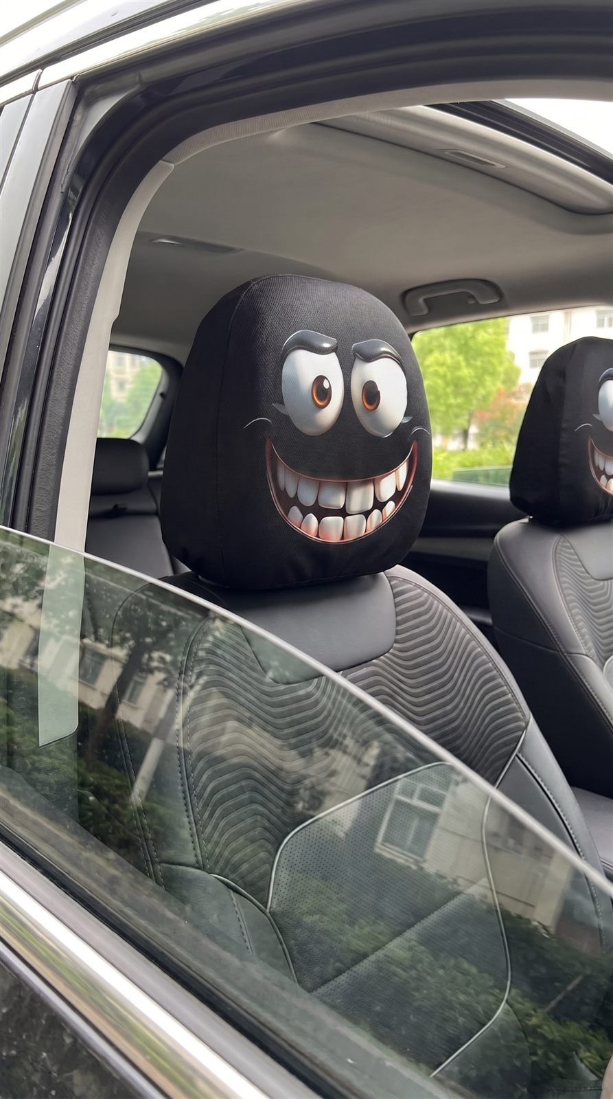 Playful cartoon smile on a black car headrest cover